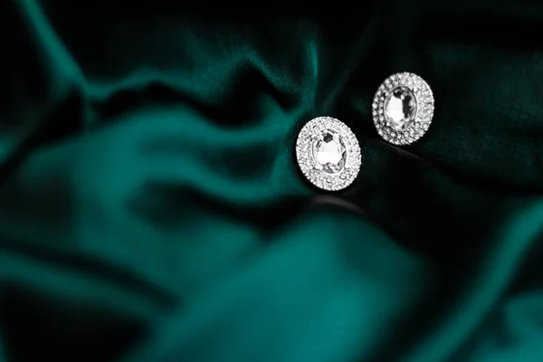 Pendientes de diamantes de lujo en seda verde esmeralda oscura, glamour navideño —  Fotos de Stock