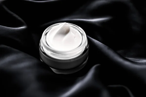 Luxury sensitive skincare moisturizing face cream on black silk