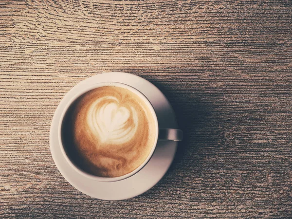 Tasse heißen Cappuccino in der Cafeteria, Kaffee auf einem Holztisch — Stockfoto