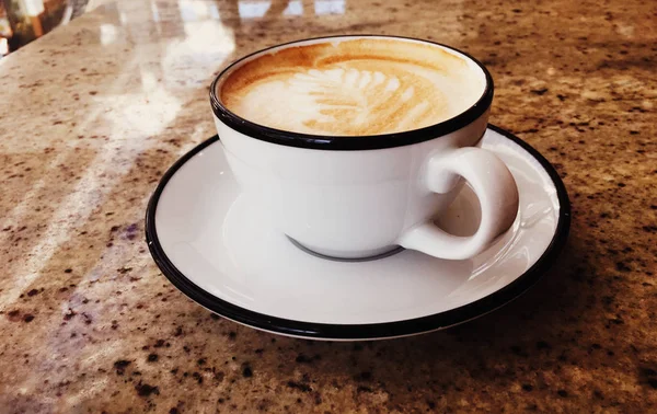 Cappuccino pour le petit déjeuner à la cafétéria, tasse de café sur la table en pa — Photo