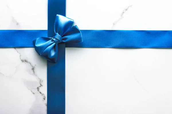 Blue silk ribbon and bow on luxury marble background, holiday fl — Stock Photo, Image