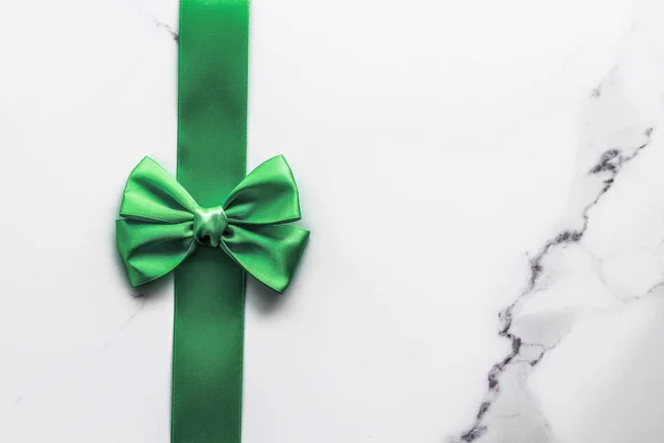 Зеленая шелковая лента и лук на мраморном фоне, День Святого Патрика — стоковое фото