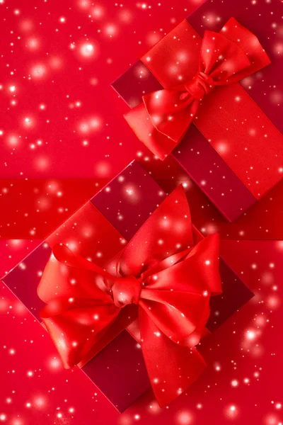 Kırmızı arka planda kış tatil hediyeleri ve parlayan kar, christm — Stok fotoğraf