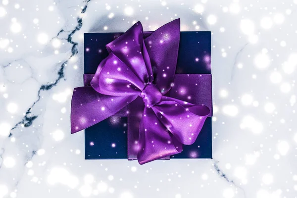 Coffret cadeau de vacances d'hiver avec arc en soie violet, paillettes de neige sur ma — Photo