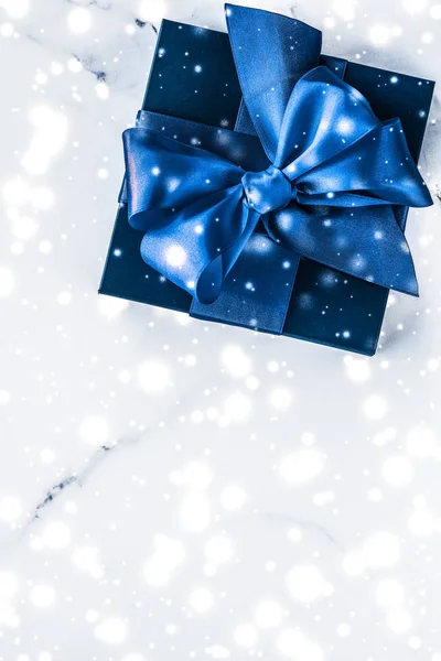 Vinter semester presentförpackning med blå silke båge, snö glitter på marb — Stockfoto