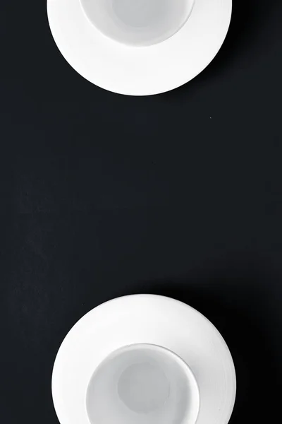 Vajilla blanca juego de vajilla, taza vacía en fondo plano negro — Foto de Stock