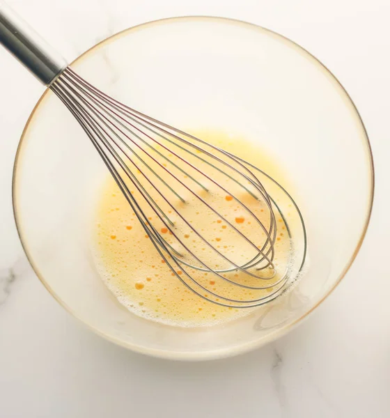 Making of mixing eggs in bowl on marble table as homemade food f — Stock Photo, Image