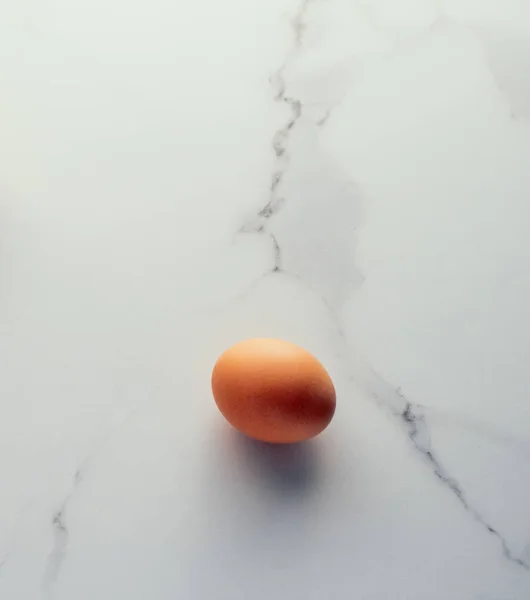 Egg on marble table as minimalistic food flat lay, top view food