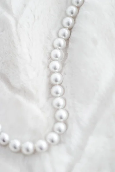 Χειμερινές διακοπές κοσμήματα μόδας, μαργαριτάρι κολιέ σε γούνα backgrou — Φωτογραφία Αρχείου