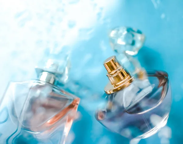 Mavi suyun altında parfüm şişesi, parıltı gibi tatlı deniz kıyısı kokusu. — Stok fotoğraf
