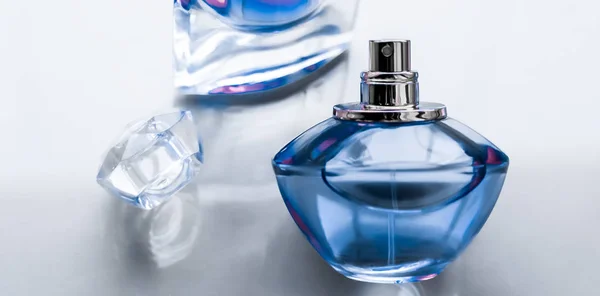 Blue perfume bottle on glossy background, sweet floral scent, gl — Stock Photo, Image