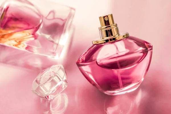 Bottiglia di profumo rosa su sfondo lucido, dolce profumo floreale, gl — Foto Stock