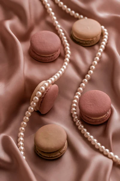 Süße Makronen und Perlen Schmuck auf Seidengrund, Parisia — Stockfoto