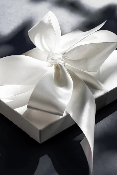 Luksusowe wakacje biały prezent pudełko z jedwabną wstążką i łuk na czarno — Zdjęcie stockowe