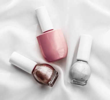 İpek arka planda oje şişeleri, Fransız manikür ürünleri.