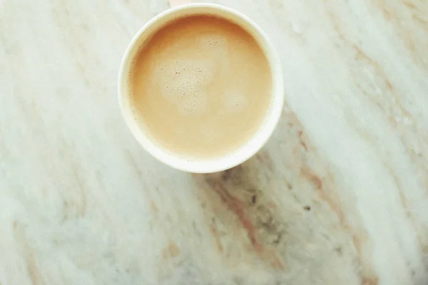 Taza de café de la mañana con leche en piedra de mármol plano laico, bebida caliente — Foto de Stock
