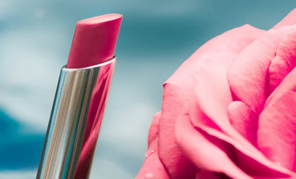 Lápiz labial rosa y flor de rosa sobre fondo líquido, impermeable g —  Fotos de Stock