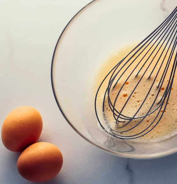 Παρασκευή αυγών ανάμειξης σε μπολ σε μαρμάρινο τραπέζι ως σπιτικό φαγητό f — Φωτογραφία Αρχείου