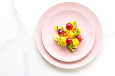 Yiyecek, içecek ve diyet konsepti - Pembe tabakta taze meyve vegan salatası, sağlıklı beslenme ve detoks