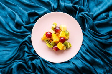 Yiyecek, içecek ve diyet konsepti - Pembe tabakta taze meyve vegan salatası, sağlıklı beslenme ve detoks