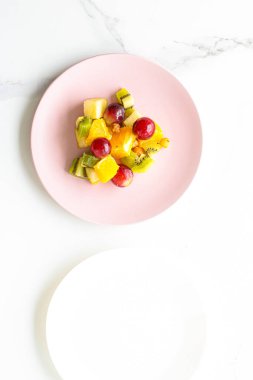 Yiyecek, içecek ve diyet konsepti - Pembe tabakta taze meyve vegan salatası, sağlıklı beslenme ve detoks