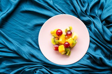 Yiyecek, içecek ve diyet konsepti - Pembe tabakta taze meyve vegan salatası, sağlıklı beslenme ve detoks