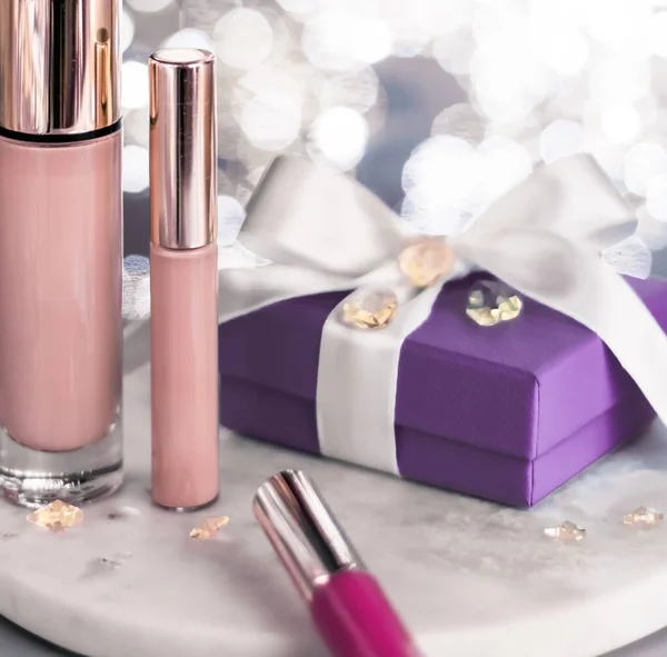 Holiday make-up set of luxury cosmetics and beauty products as a gift on shiny glitter background