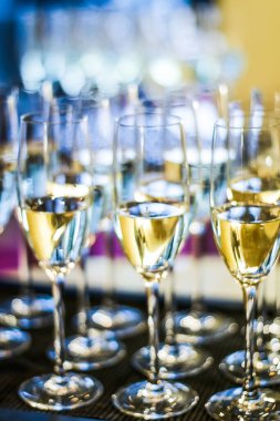 Hayır etkinliğinde sunulan şampanya ve köpüklü şarap kadehleri, yakın planda içilen alkollü içkiler.