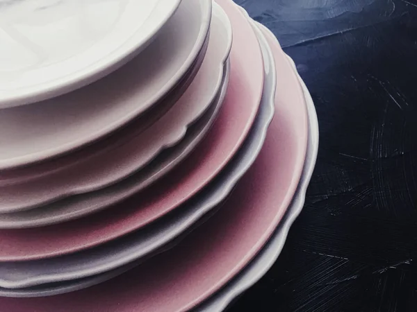 Stack of clean empty plates on black background, dishware and table decor — Stock fotografie