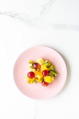 Pembe tabakta taze organik meyve salatası, sağlıklı beslenme ve detoks diyeti