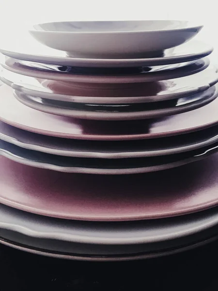 Stack of clean empty plates on black background, dishware and table decor — Stock fotografie