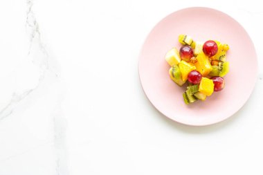 Pembe tabakta taze organik meyve salatası, sağlıklı beslenme ve detoks diyeti