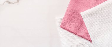 Katlanmış peçete ve mutfak havlusu beyaz mermer arka planda, masa dekorunda.