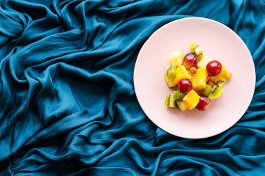 Pembe tabakta taze organik meyve salatası, sağlıklı beslenme ve detoks diyeti