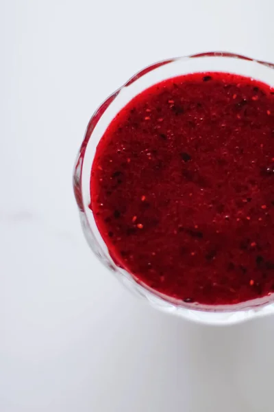 Zoete aardbei jam in een glazen dessertkommetje op marmeren tafel — Stockfoto