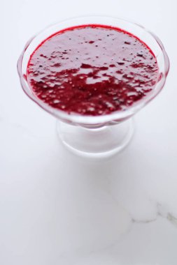 Tatlı çilek reçeli mermer masada cam bir tatlı kasesinde