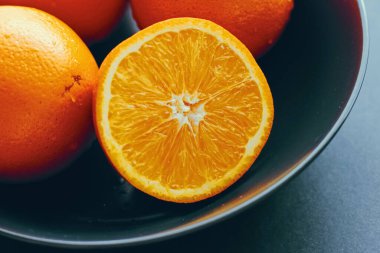 Siyah kasede taze sulu portakallar, sağlıklı beslenme ve beslenme