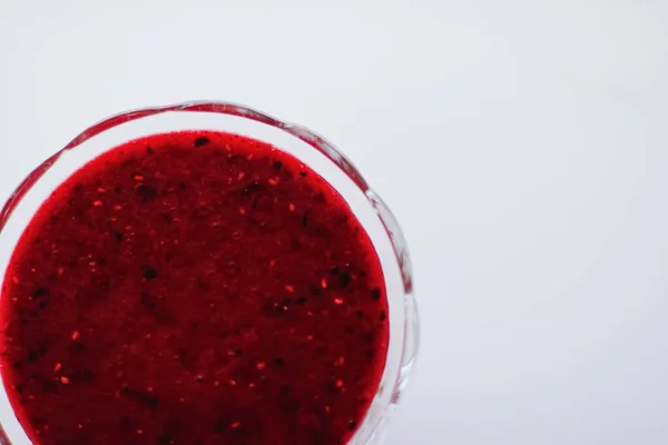 Sweet strawberry jam in a glass dessert bowl on marble table — Stock fotografie