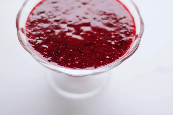 Zoete aardbei jam in een glazen dessertkommetje op marmeren tafel — Stockfoto