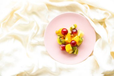 Pembe tabakta taze organik meyve salatası, sağlıklı beslenme ve detoks diyeti