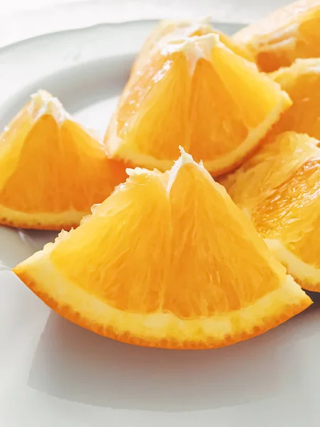 Slices of juicy orange on white plate, healthy diet and nutrition