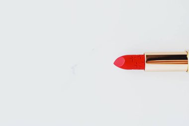 Beyaz mermer arka planda altın bir tüp içinde lüks ruj, makyaj ve kozmetik