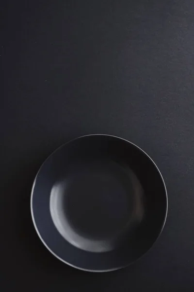 Platos vacíos sobre fondo negro, vajilla premium para la cena de vacaciones, diseño minimalista y dieta —  Fotos de Stock