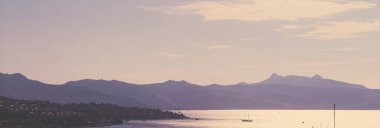 Akdeniz 'deki deniz manzarası ve dağlar gün batımında, yaz tatili seyahatleri ve tatil beldeleri