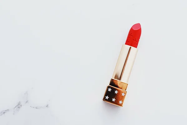Luxury lipstick in a golden tube on white marble background, make-up and cosmetics — Stock Photo, Image