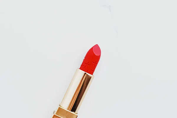 Lápiz labial de lujo en un tubo dorado sobre fondo de mármol blanco, maquillaje y cosméticos — Foto de Stock