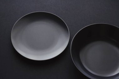 Siyah arka planda boş tabaklar, bayram yemeği için kaliteli bulaşık takımı, minimal tasarım ve diyet
