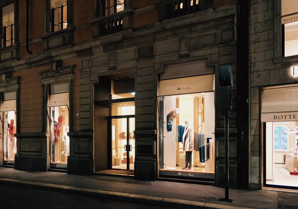 Milan, Italy circa January, 2020: Historical buildings, stores and boutique shops on Via Montenapoleone street in Milan at night, luxury shopping street