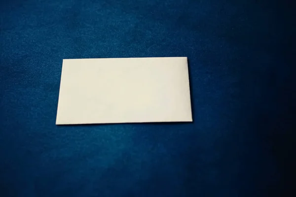 Pusta beżowa kartka papierowa na niebieskim tle, makieta biznesowa i luksusowa marka — Zdjęcie stockowe