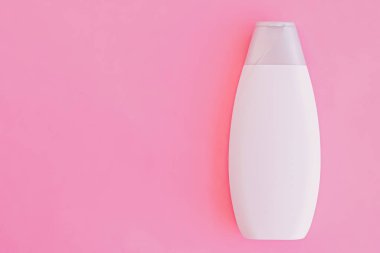 Pembe arka planda boş etiket şampuan şişesi veya duş jeli, güzellik ürünü ve vücut bakım ürünleri